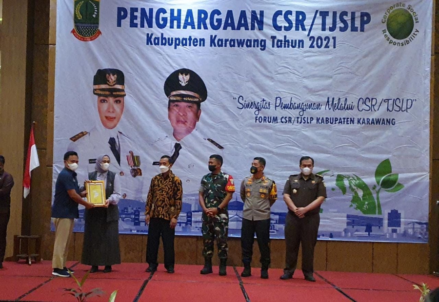 Pupuk Kujang diberi penghargaan CSR Award dari Pemkab Karawang. Sekretaris Perusahaan, Ade Cahya Kurniawan saat menerima piagam penghargaan dari Bupati Karawang, Cellica Nurrachadiana.  (ag/PKBL)